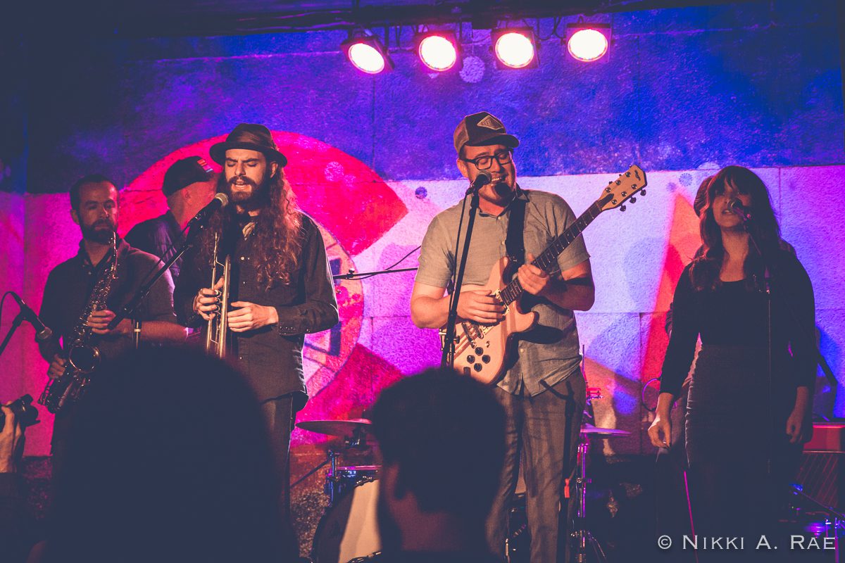 Band performing on stage with instruments.