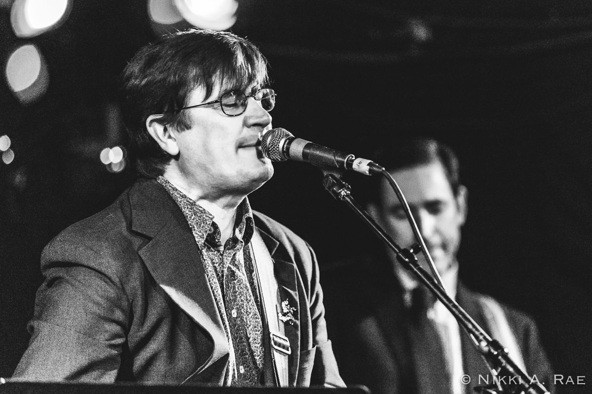 Singer performing live with microphone on stage.