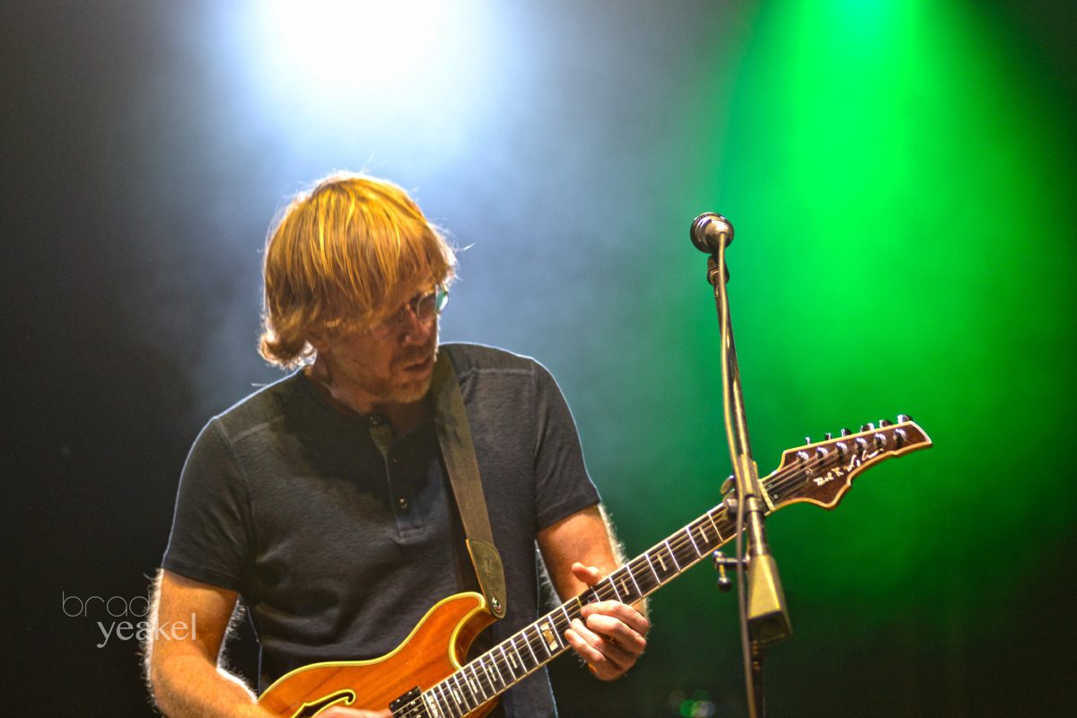Guitarist performing under colorful stage lights.