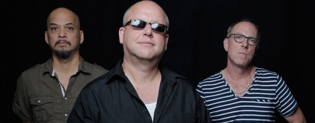 Three men posing against a dark background.