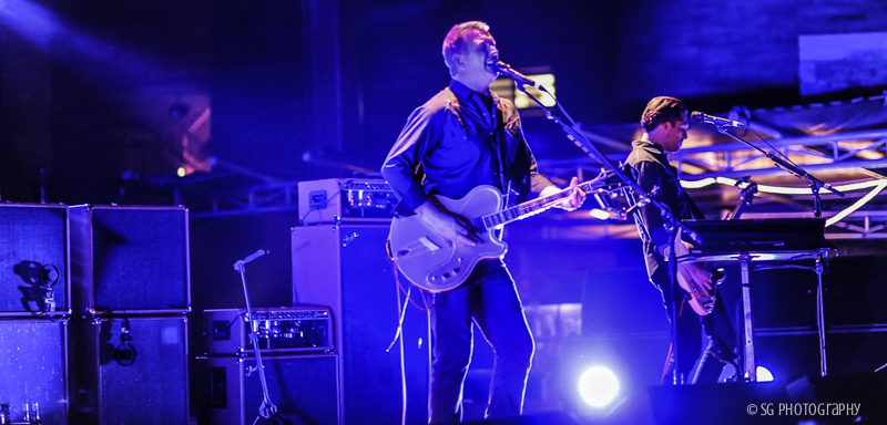 Band performing live on stage with guitars.