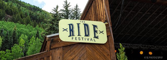 The Ride Festival sign with trees background.