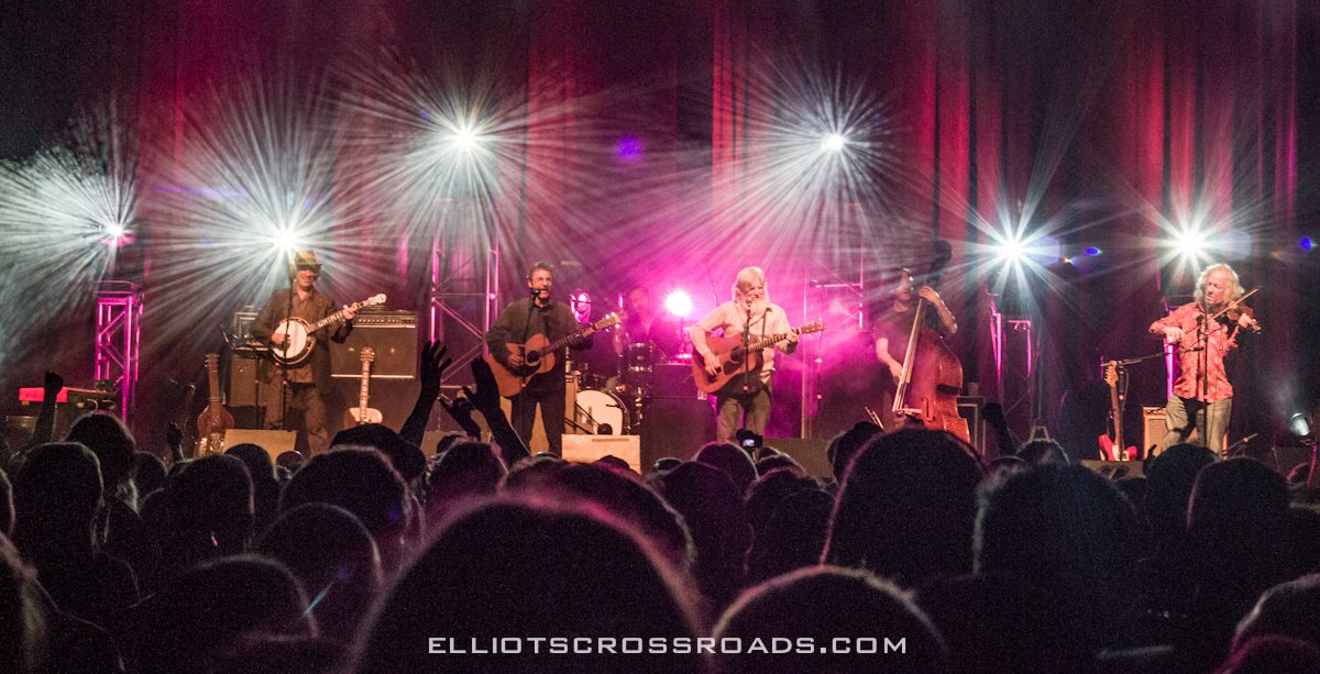 Band performing on stage with bright lights.