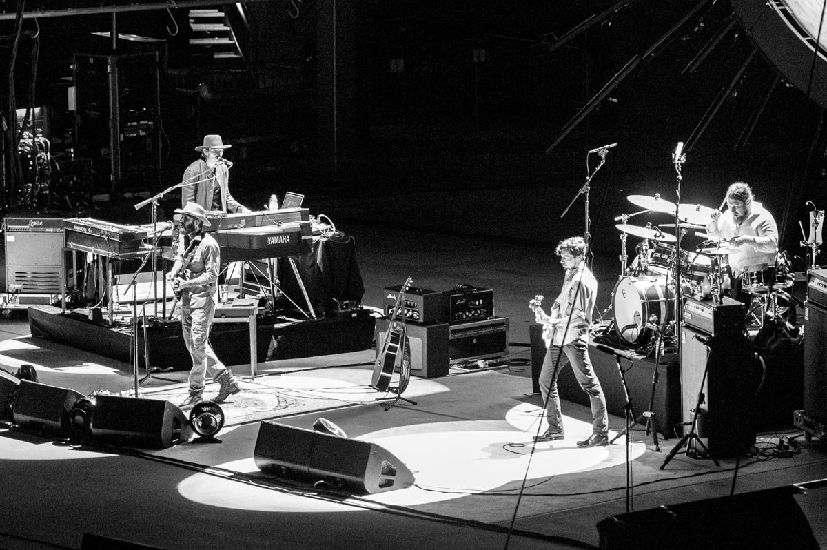 Band performing live on stage in monochrome.