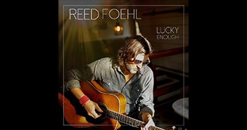 Man playing guitar on album cover.