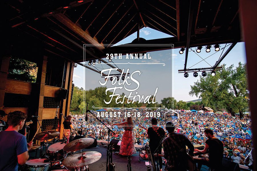 Musicians performing at outdoor folk festival stage.