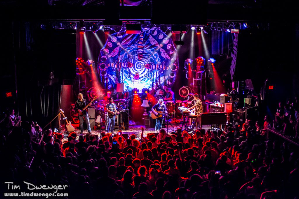 Live band performing on stage with audience.