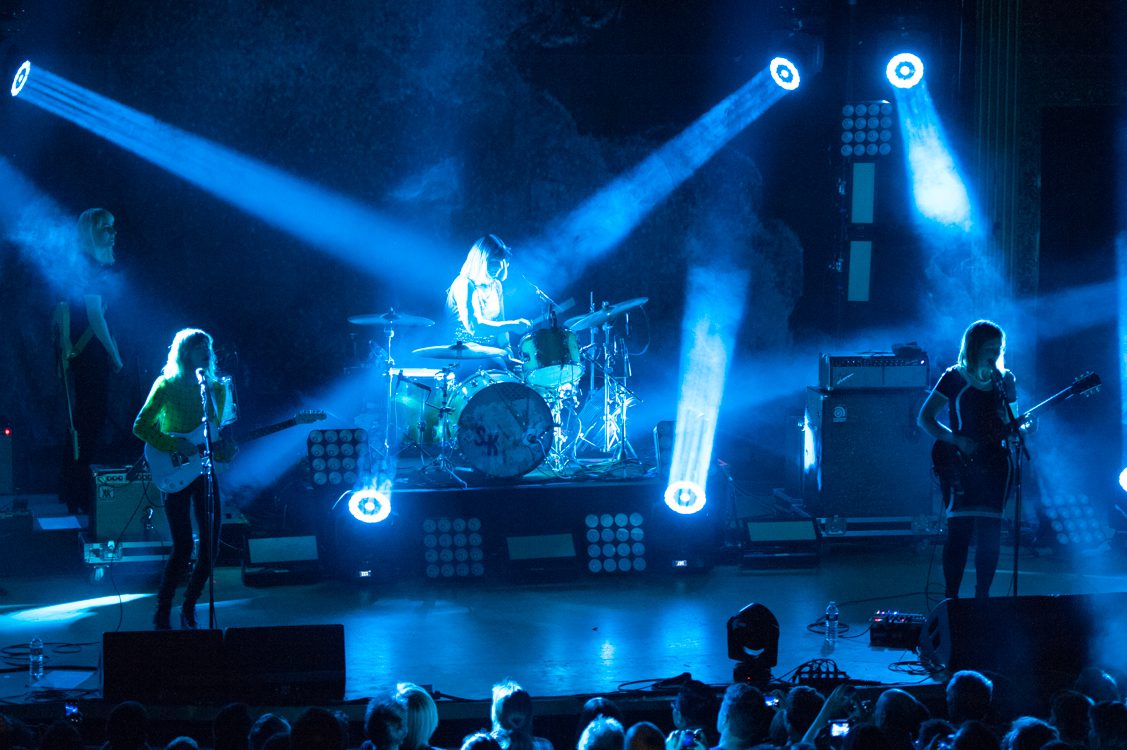 Band performing on stage with blue lights.