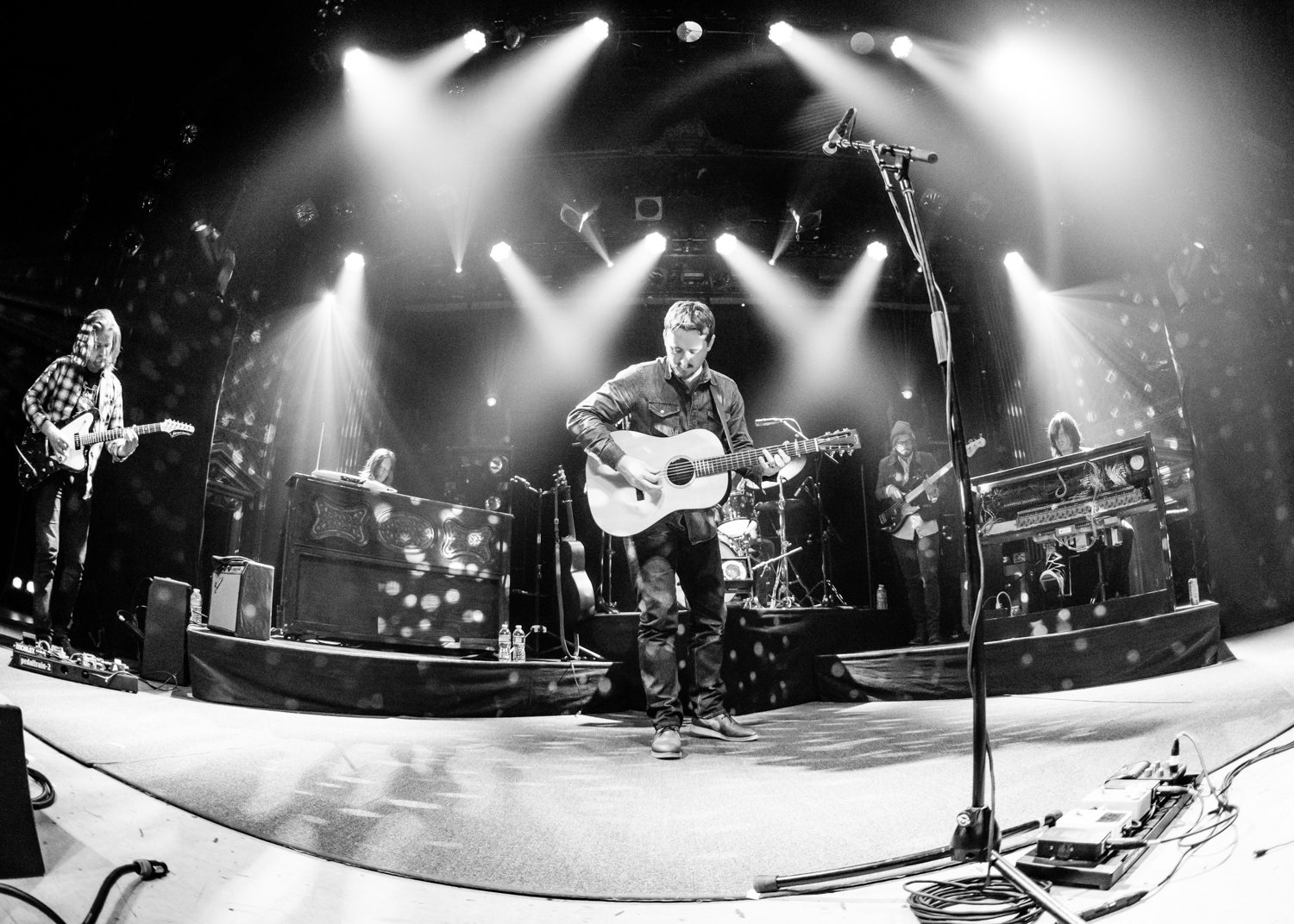 Band performing live on stage with guitars.