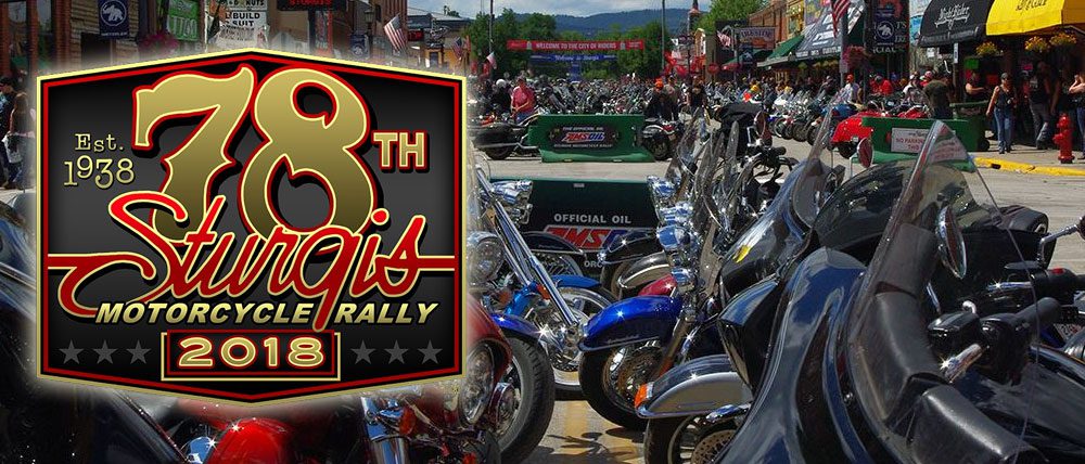 Motorcycle rally with parked bikes and banner.