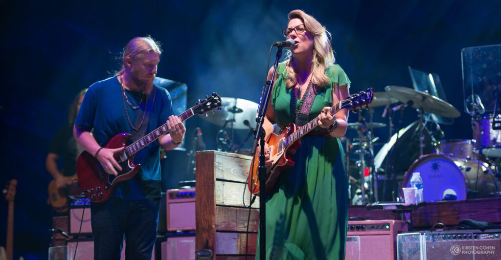 Musicians performing on stage with guitars.
