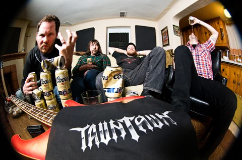 Band members relaxing with drinks and instruments.