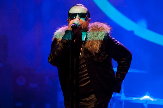 Singer performing on stage with fur jacket.