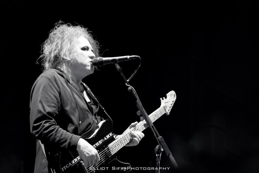 Musician performing on stage with guitar.