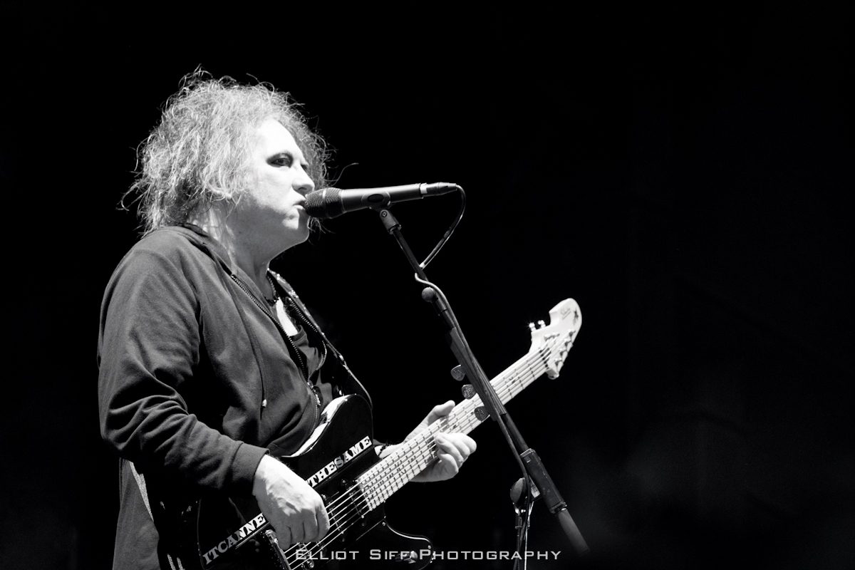 Musician performing on stage with guitar.