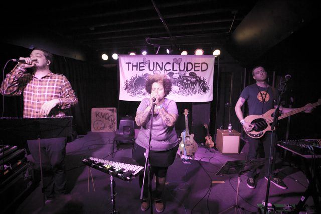 Band performing on stage with instruments.