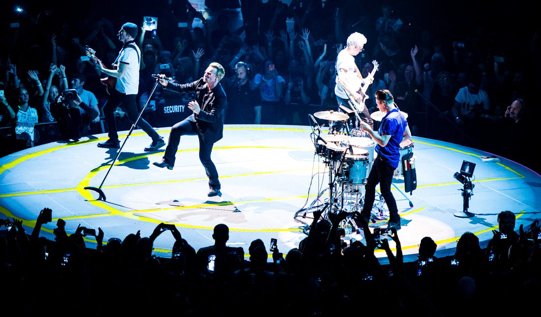 Band performing on a circular stage, live concert.