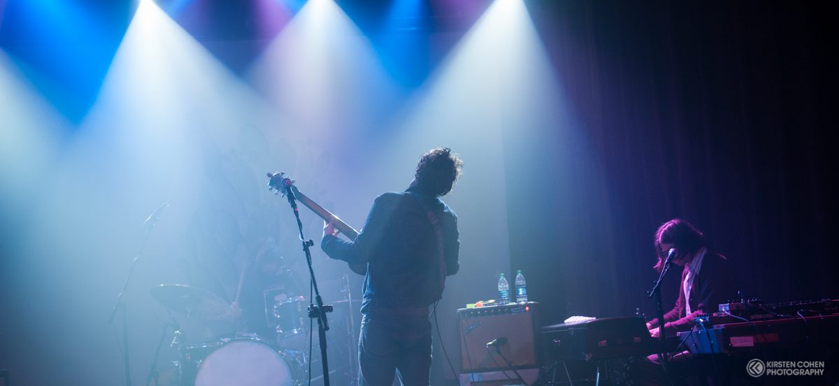 Musicians performing on stage with colorful lights.