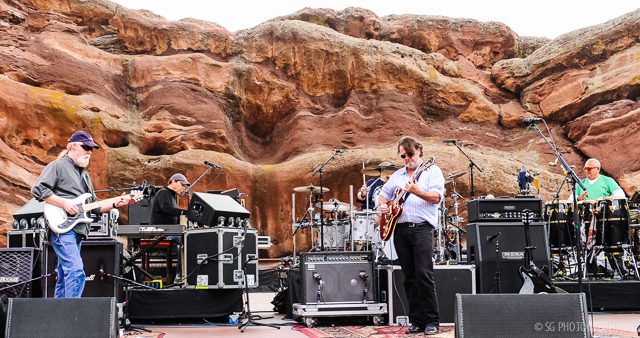 Band performing at outdoor rock amphitheater.