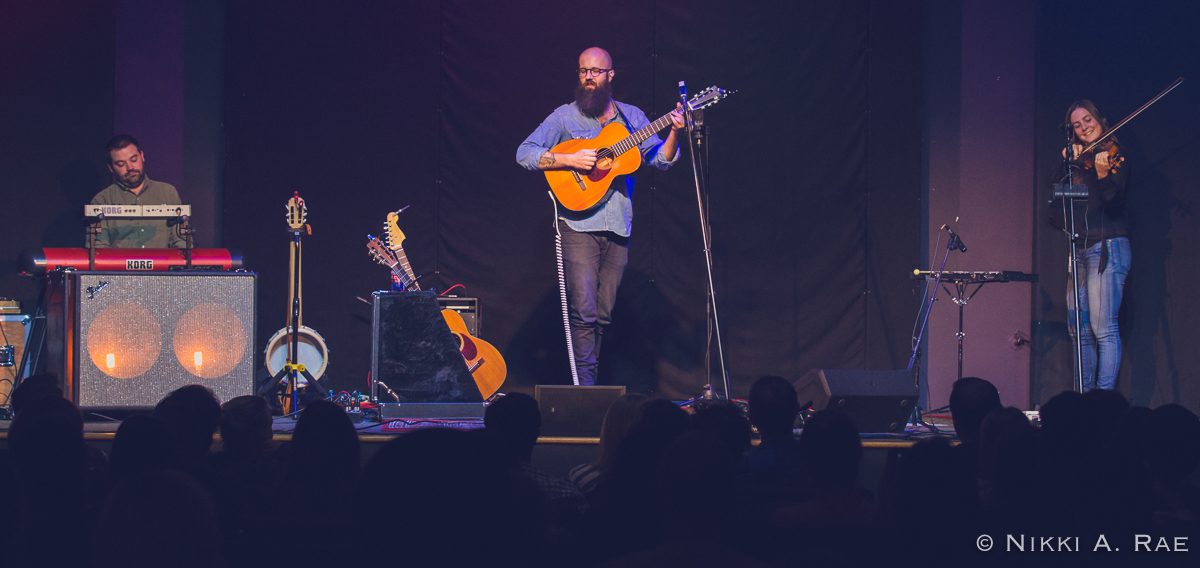 Band performing on stage with instruments.
