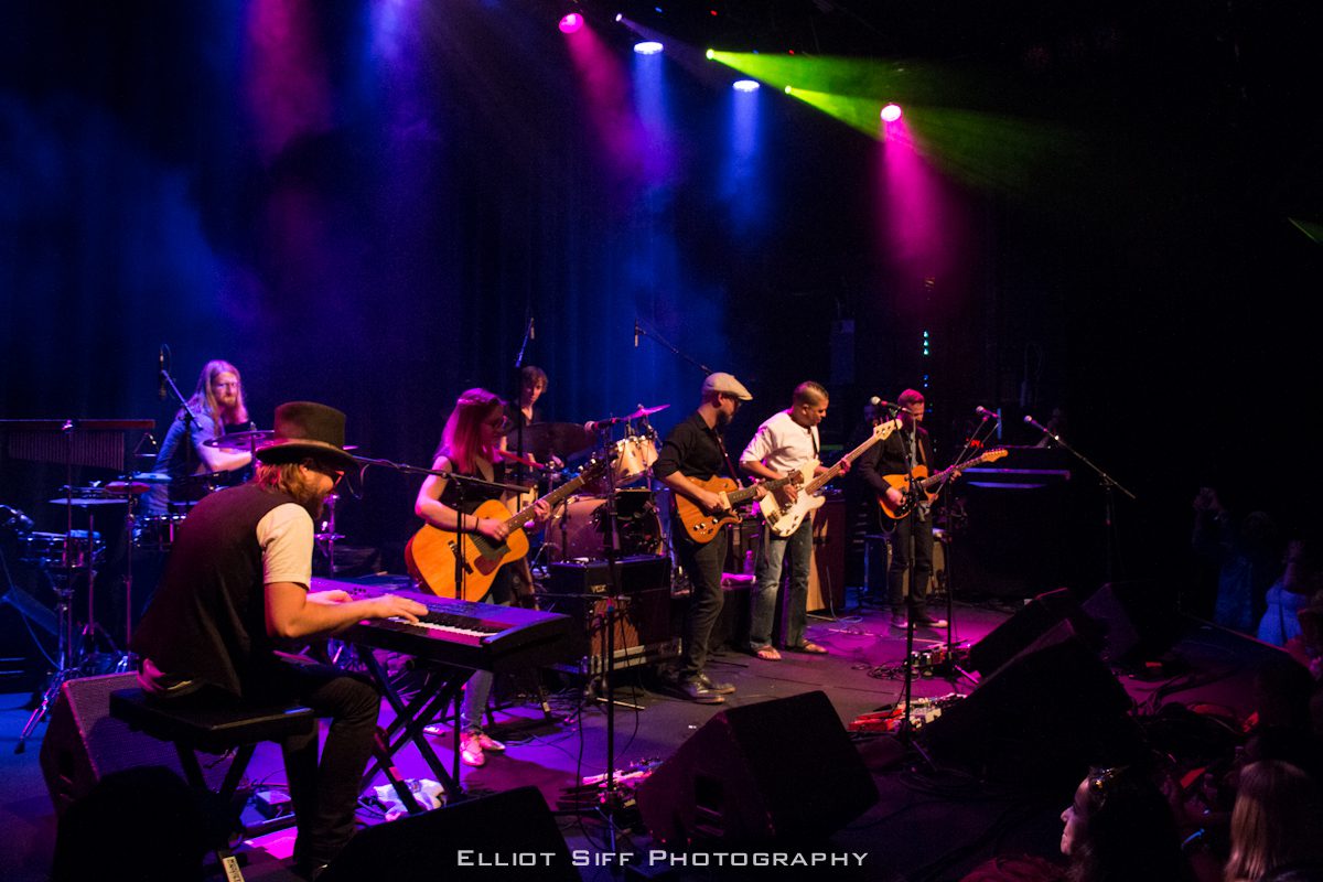 Band performing on stage with colorful lights.