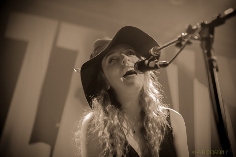 Singer performing on stage with microphone.