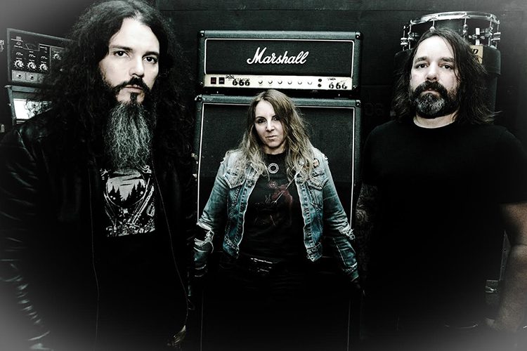 Three musicians standing by Marshall amplifier.