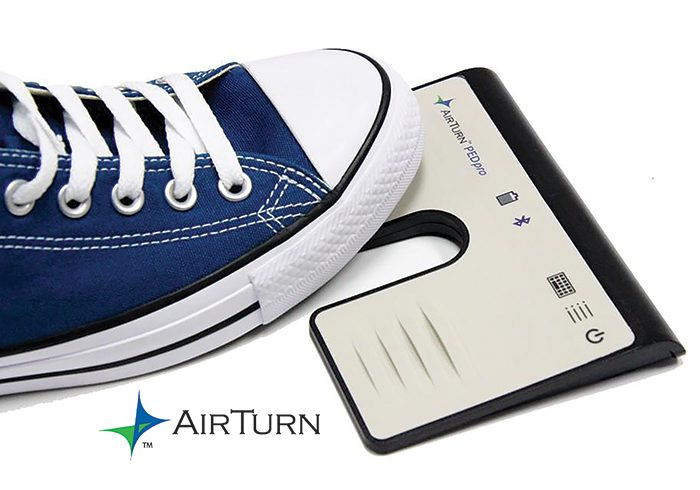 Sneaker pressing a Bluetooth foot pedal device.