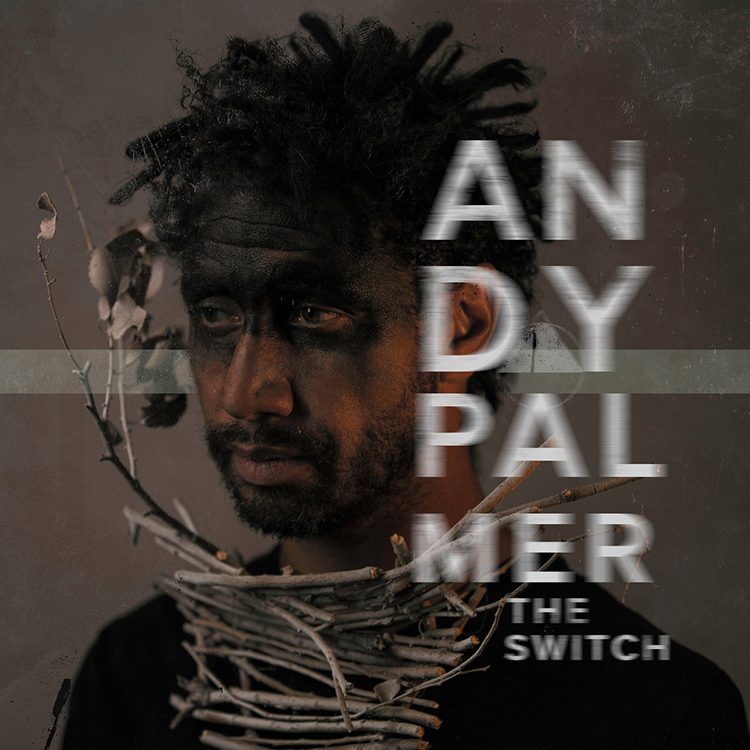 Man with branches and dark face paint.