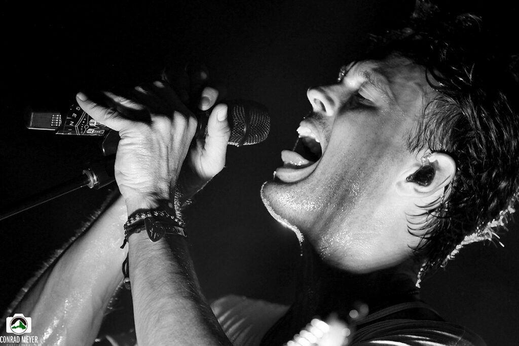Singer performing passionately with a microphone.