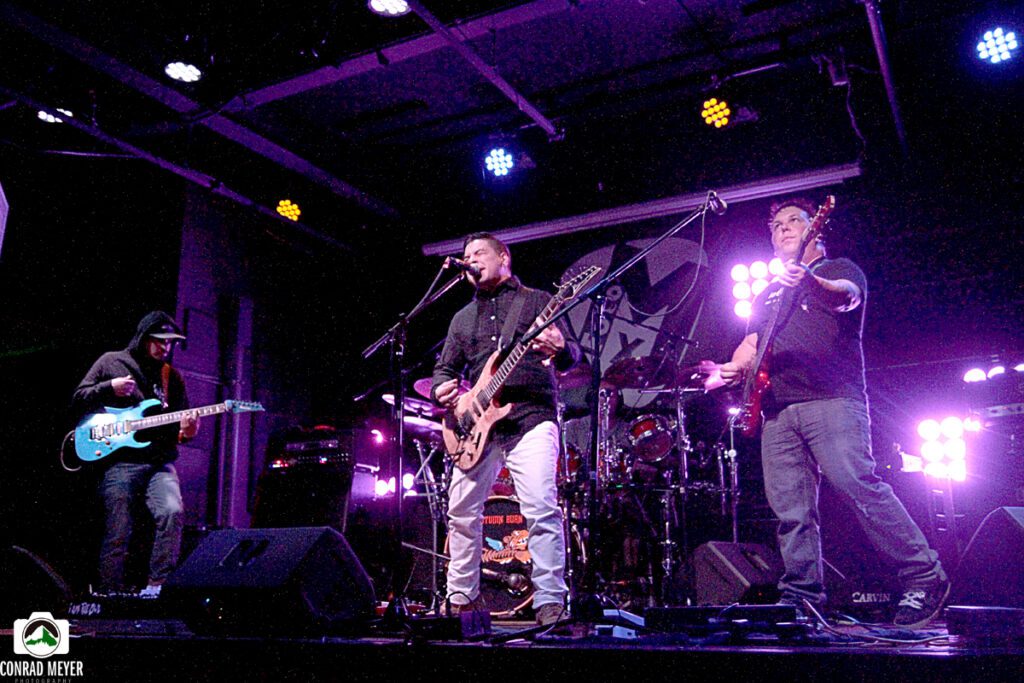Band performing live on stage with instruments.