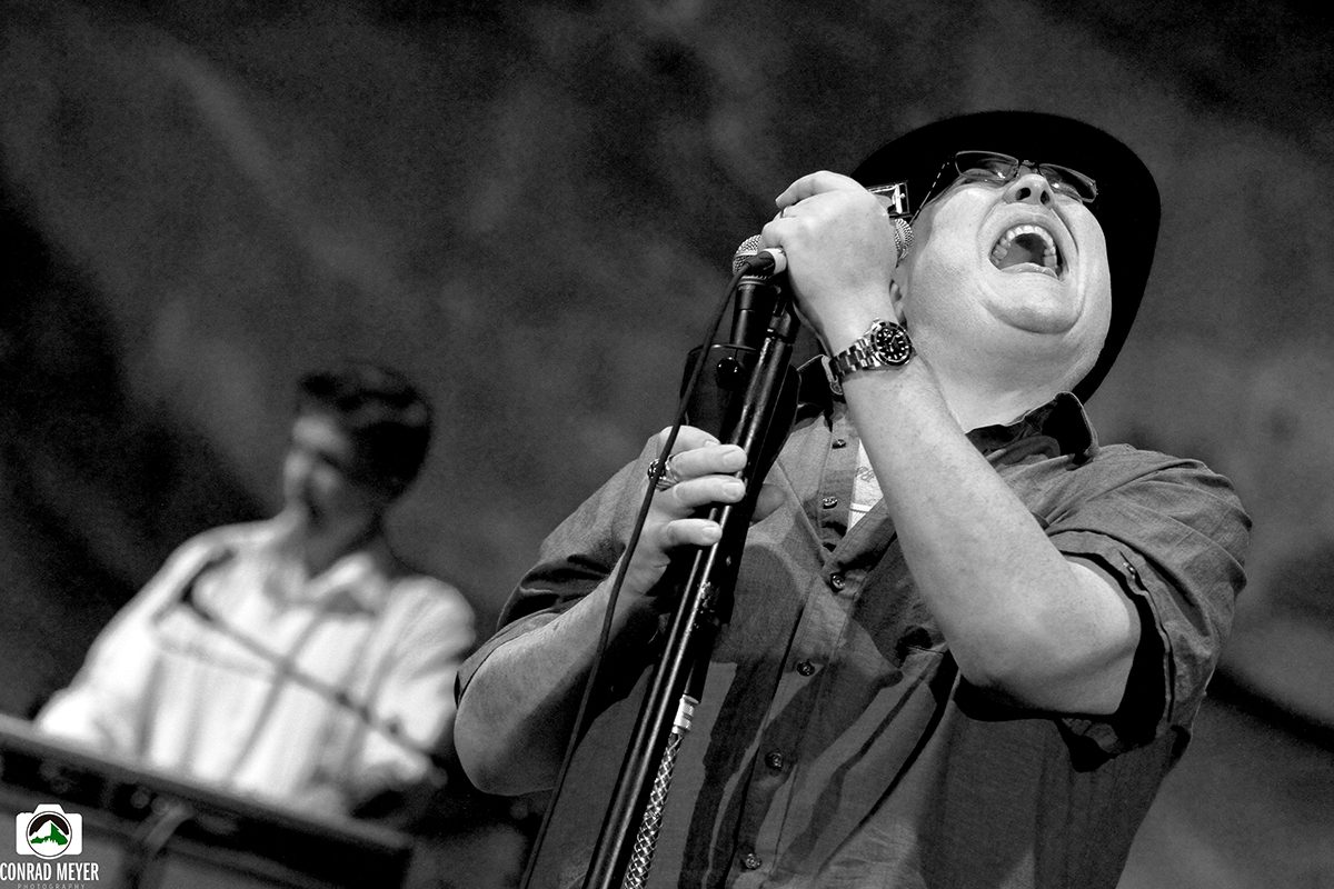 Singer passionately performing on stage with microphone.