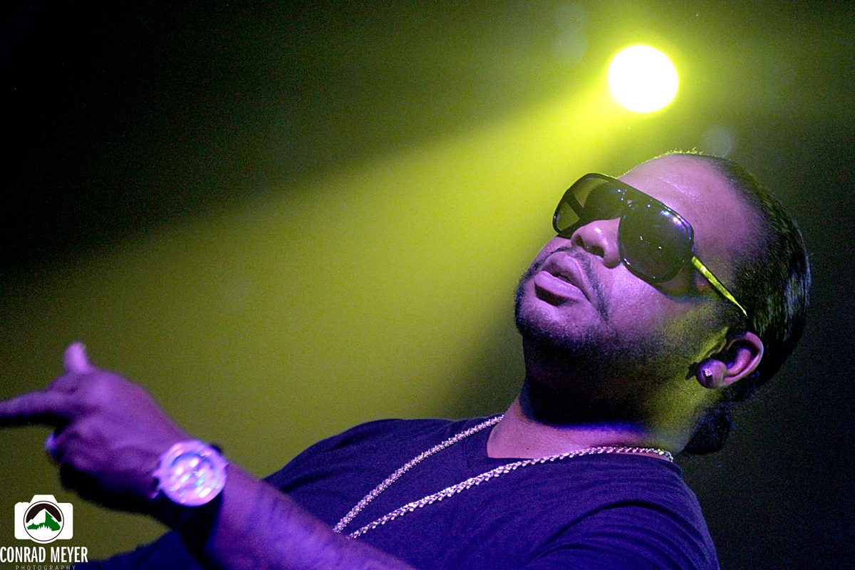 Man performing on stage under yellow light.