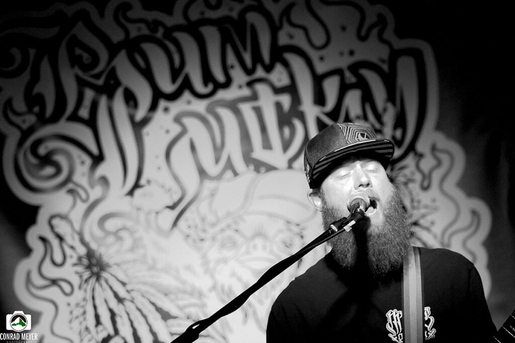 Singer performing with graffiti backdrop.