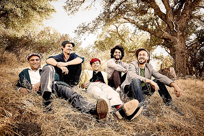 Group of people sitting outdoors, smiling.