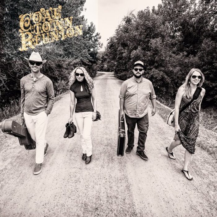 Four people walking on a rural road.