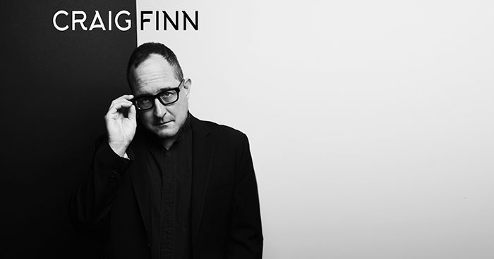 Man in black suit with glasses.