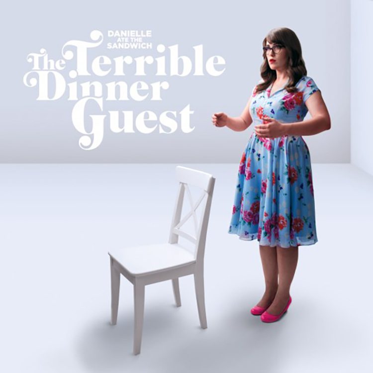 Woman in floral dress beside empty chair.