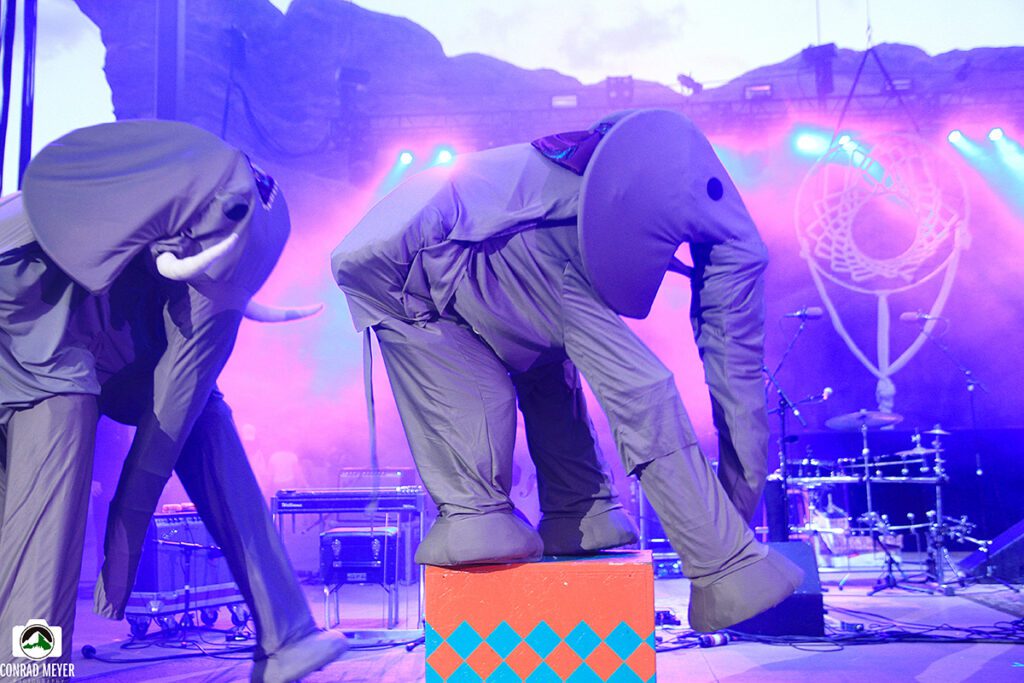 People in elephant costumes performing on stage.