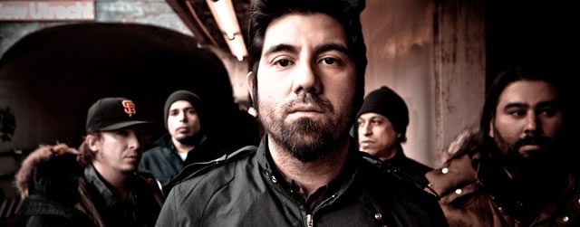 Five men standing in a dimly lit setting.