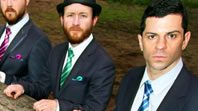 Three men in suits standing outdoors.