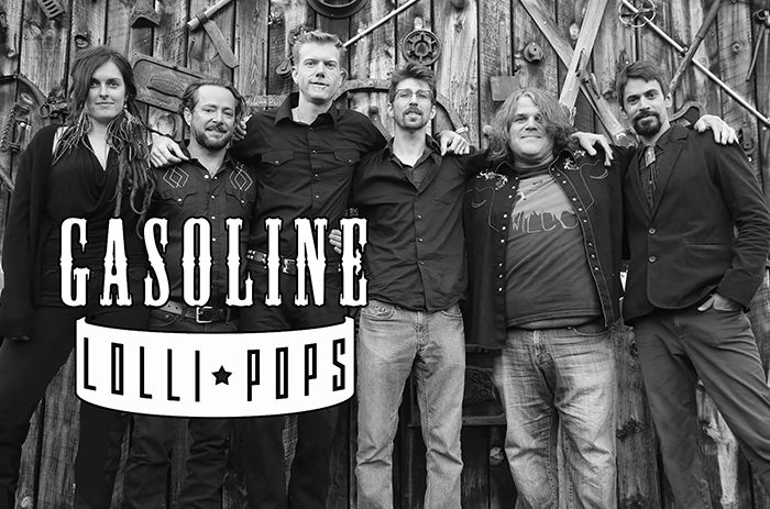 Band posing in front of wooden wall.