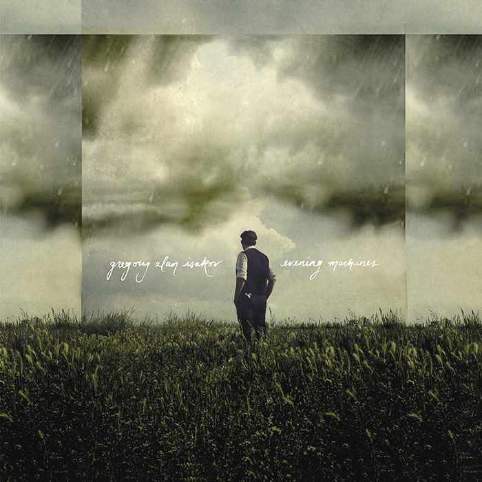 Man standing in a grassy field, cloudy sky.