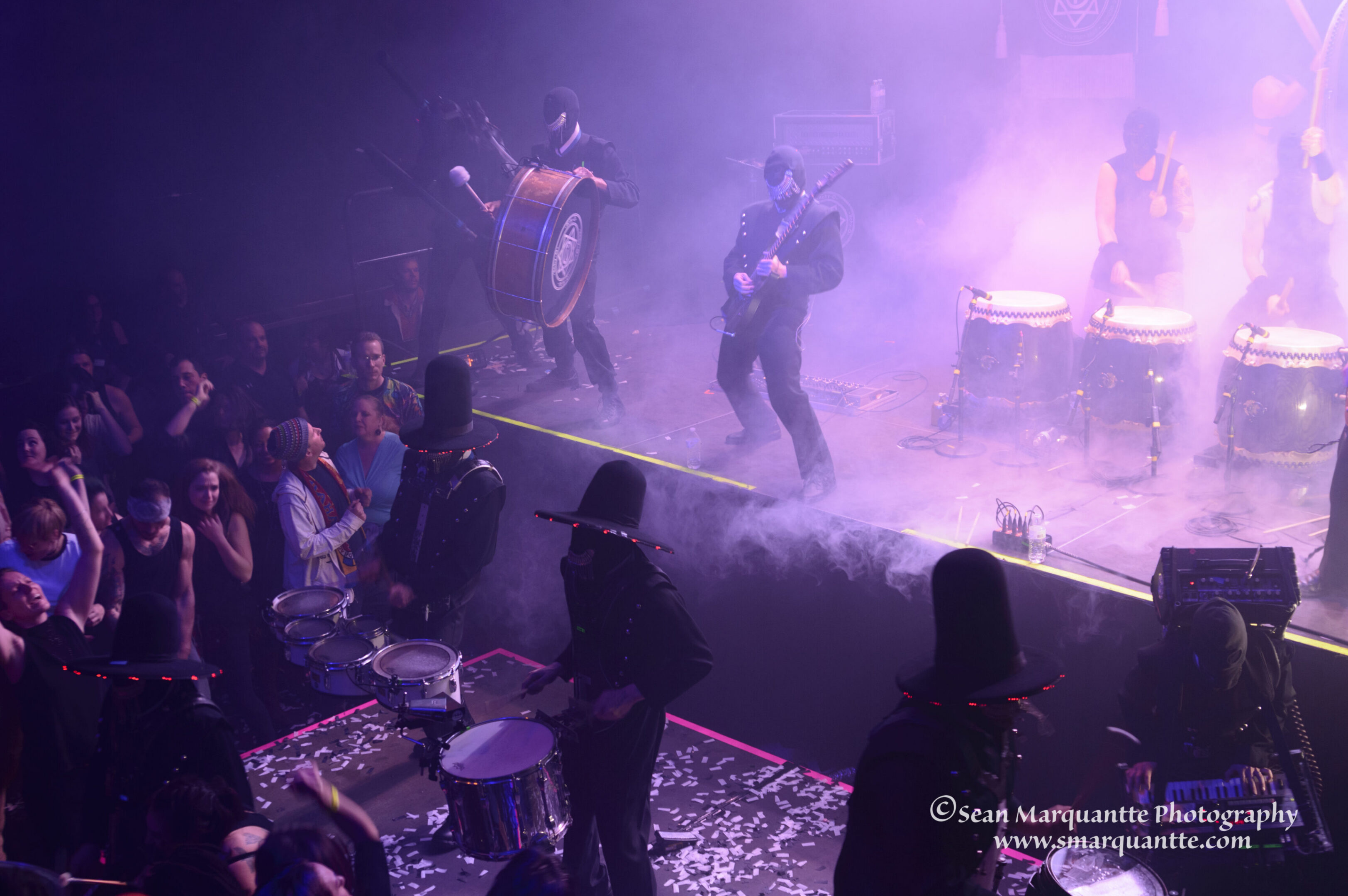 Musicians performing on stage with drums.