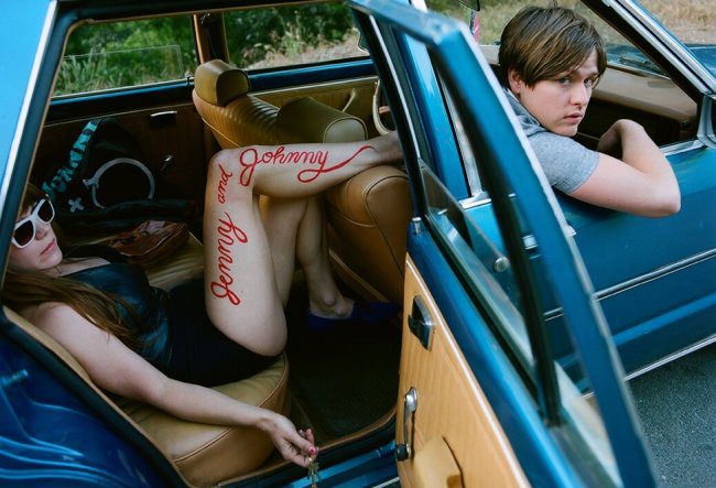 Two people in a vintage car.