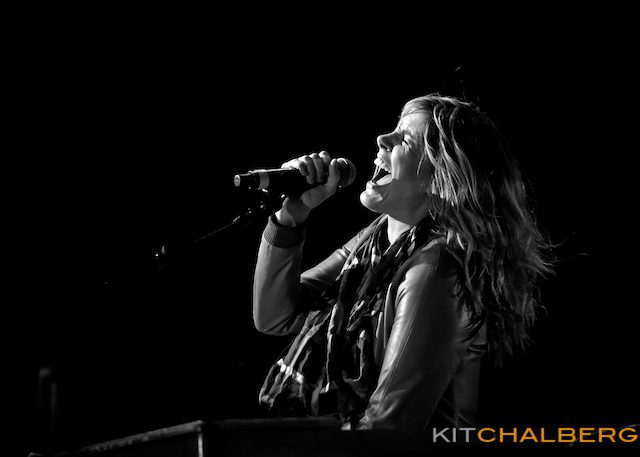 Singer passionately performing on stage, black-and-white.