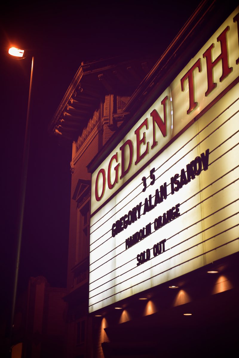 Theater marquee at night with event details.