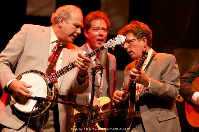 Musicians performing on stage with instruments.