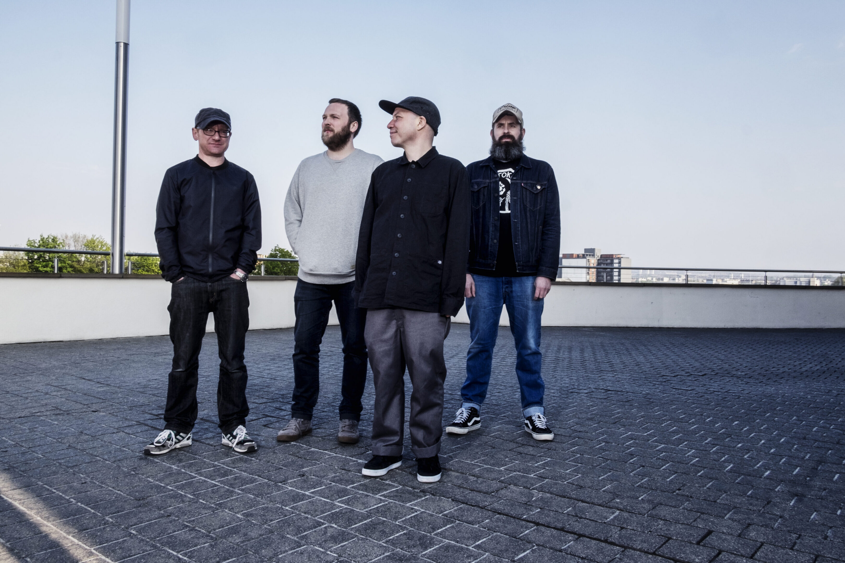 Four men standing on a rooftop.