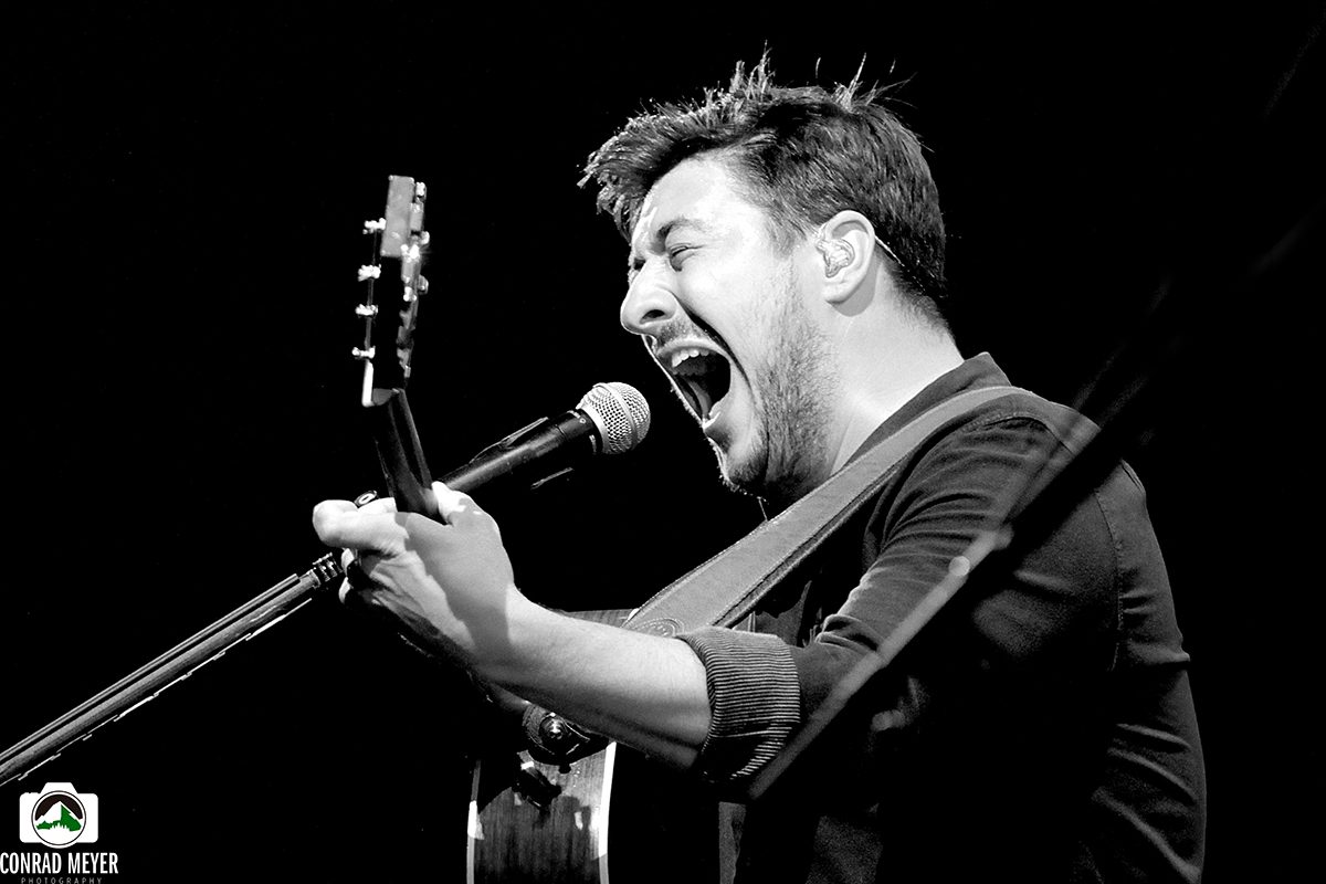 Singer passionately performing with a guitar.